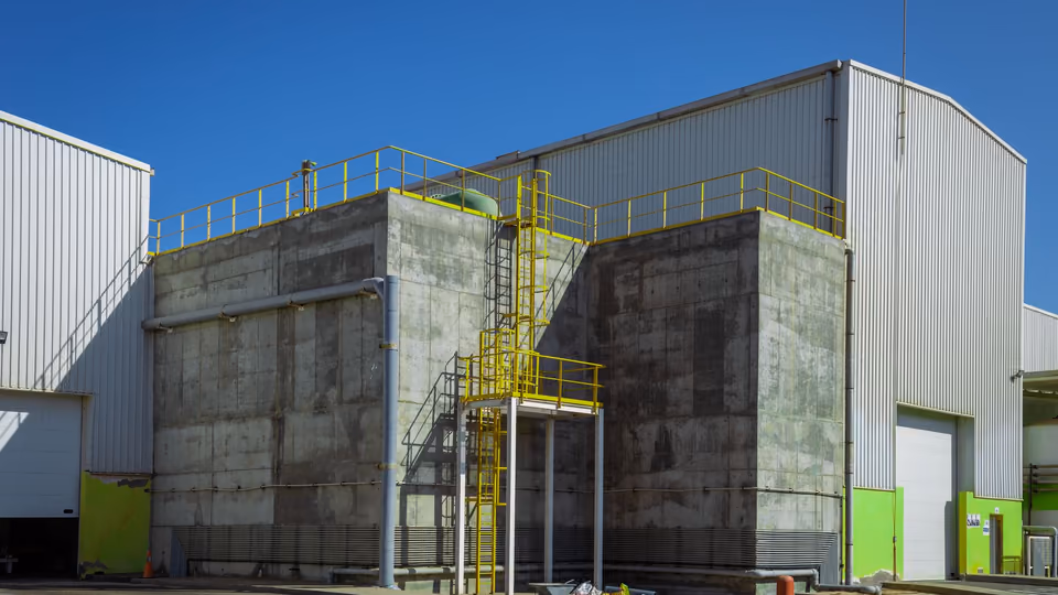 Exterior of an industrial facility with metal-clad buildings under a clear sky